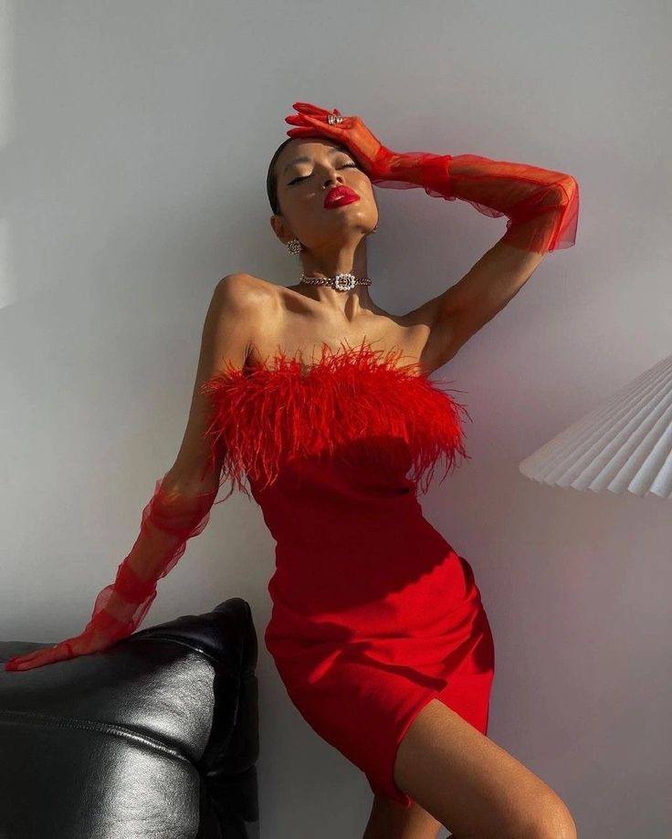 Короткое платье в красном цвете , украшенное перьями. В комплекте так же идут перчатки.